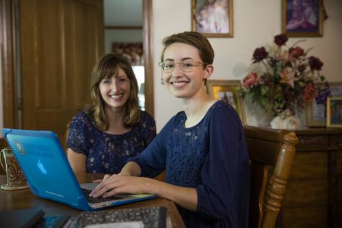 Samantha Armentor and her Mother sitting at the table on her computer