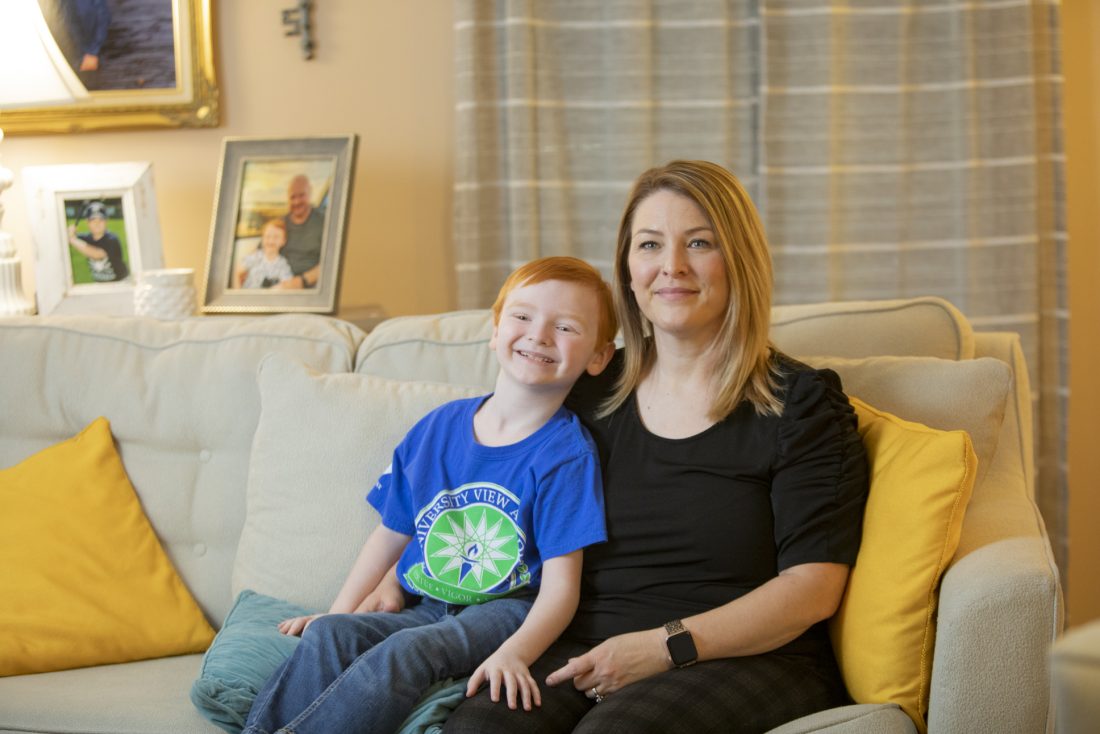 A young boy and a woman seated on a couch.