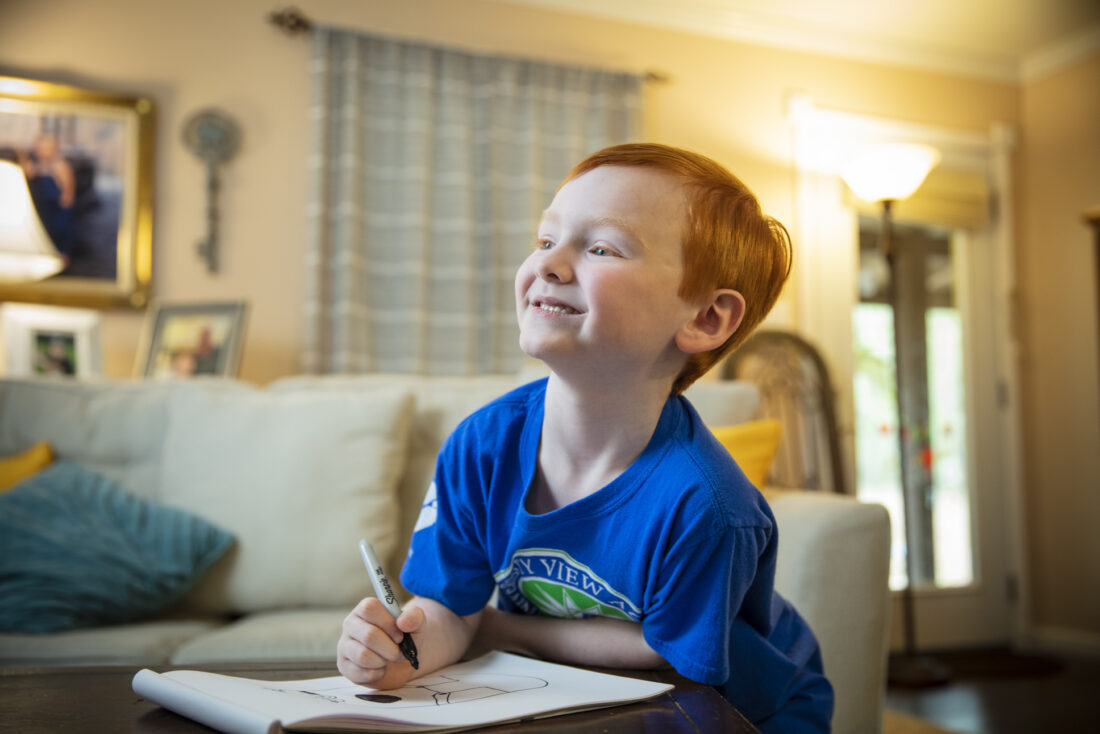 A young boy wearing a UVA shirt.