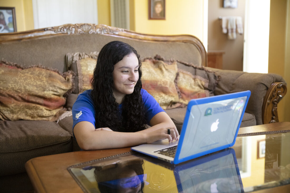 A girl working in her living room.