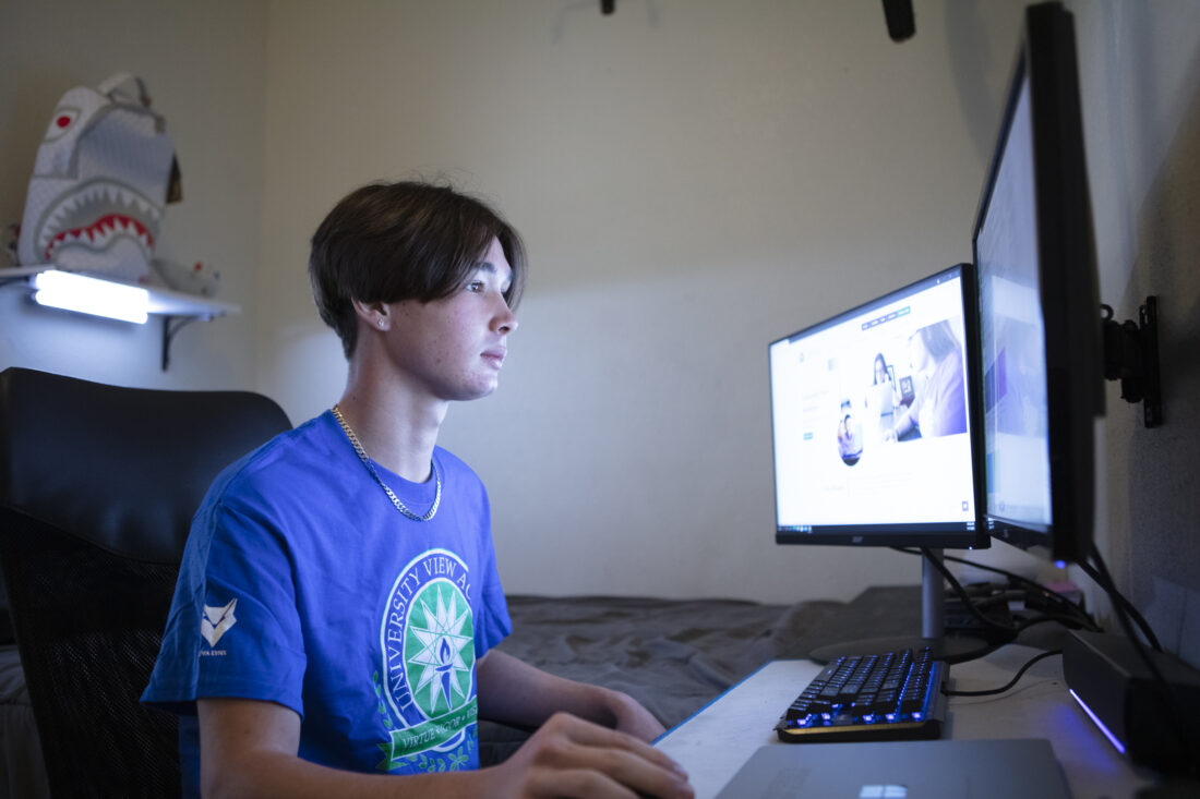 An older boy working on his computer.