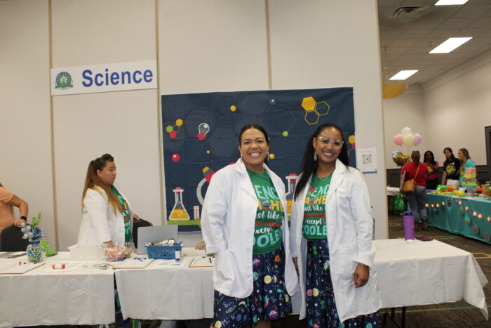 Two UVA science teachers in lab coats smiling for the camera.