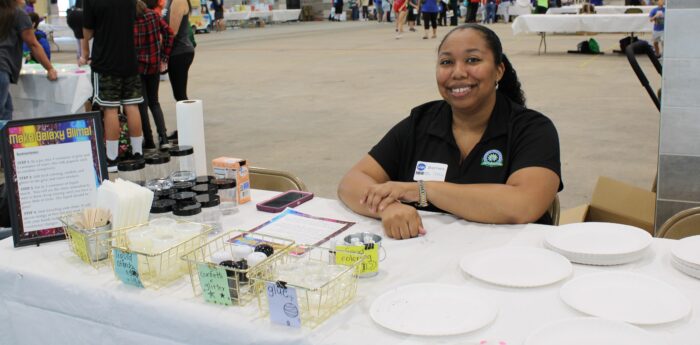 A teacher at a table with a science activity.