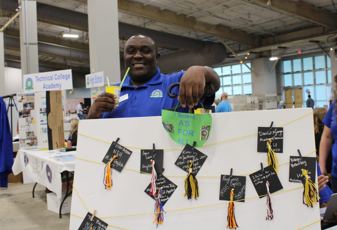 A man posing with a display board. 