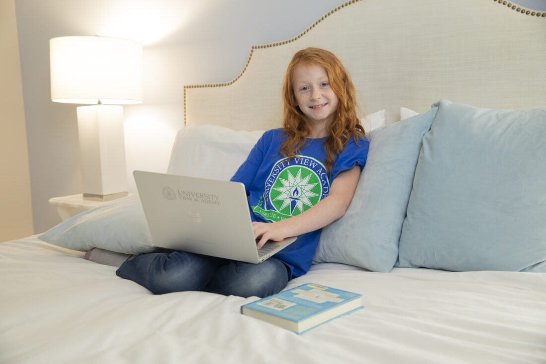 Elementary school girl with laptop for University View Academy.