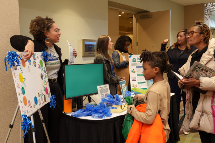 Learning Community Coach Selena Guilbeaux interacts with a family at orientation