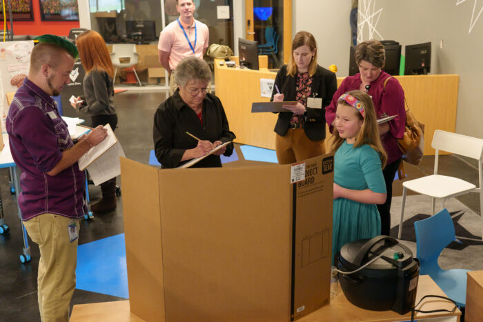 A UVA student presents her project to four judges at the science fair.
