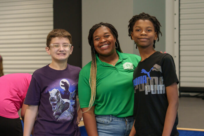 Middle school science teacher Dannica Kenner smiles for a photo with two of her students.