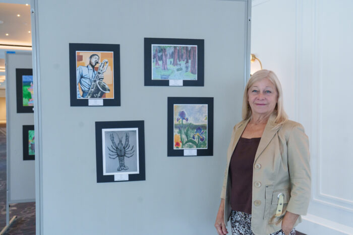 UVA talented art teacher Charlotte Collins in front of a display of student art