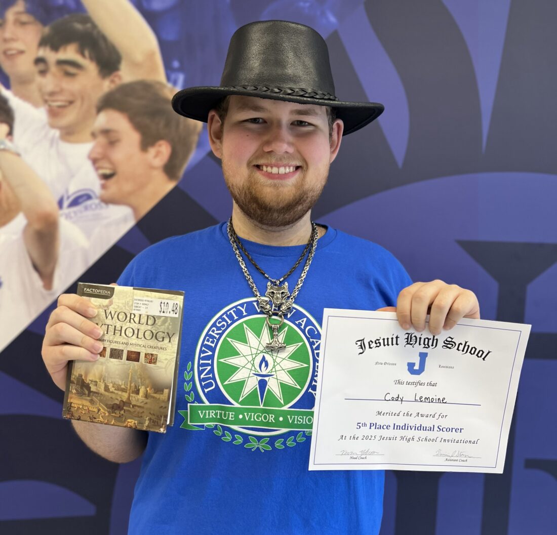 Cody Lemoine holding a book and an achievement certificate at a recent Quiz Bowl competition.