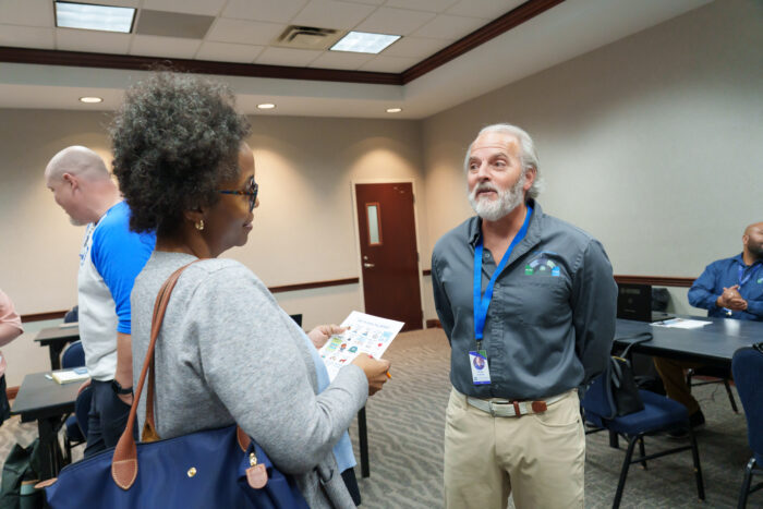 A parent at orientation talks with a family liaison.