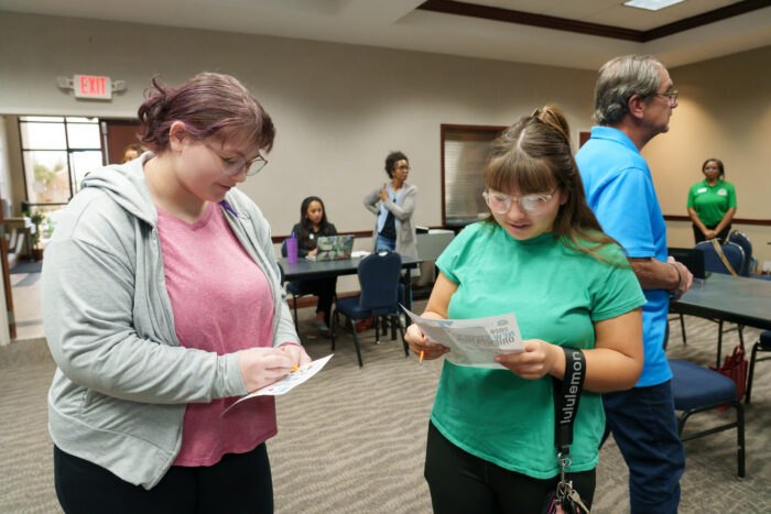Two girls compare bingo cards.
