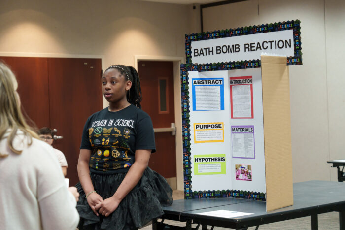 Oni P. presents her bath bomb reaction project to the judges.