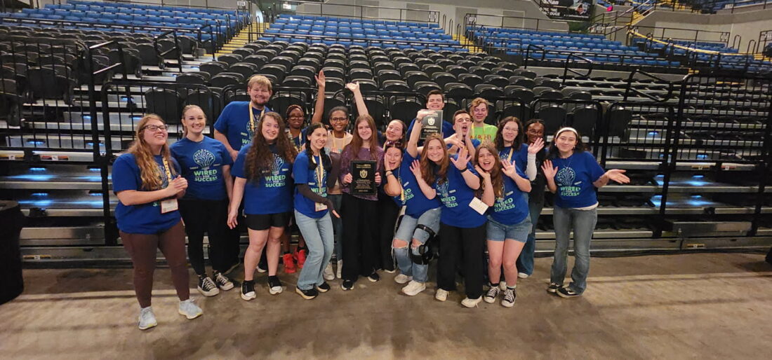 Members of UVA's high school Beta Club chapter cheer and wave at the camera.