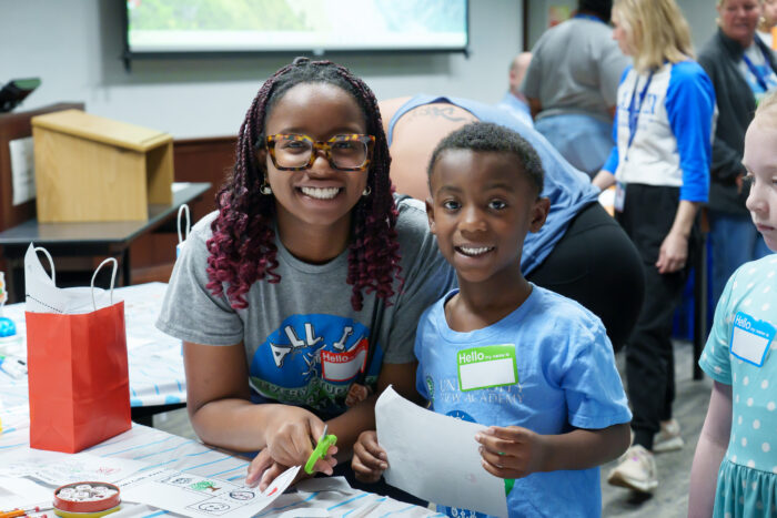 A high school student and her younger brother smile for the camera