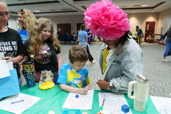 A teacher helps a student with a reading activity at Literacy Day.