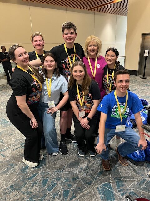 Members of high school Beta Club with sponsor Stacie Reed smile and pose for a picture