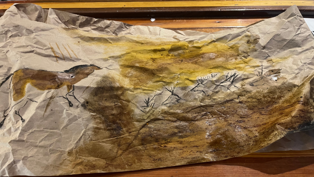 Crumpled brown paper featuring a horse painting on the left and an abstract yellow-brown landscape on the right.
