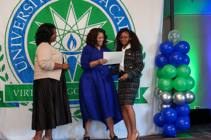 A student crossing the stage receives her certificate from Superintendent Timoll