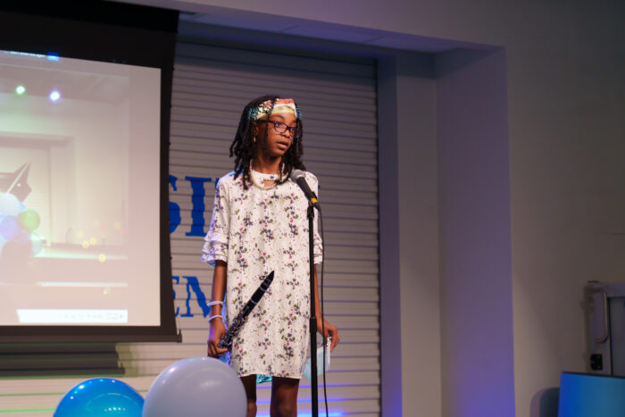 A student holding a clarinet on the Lynx Den stage.