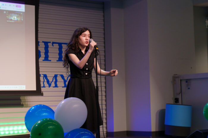 A student sings on the Lynx Den stage.