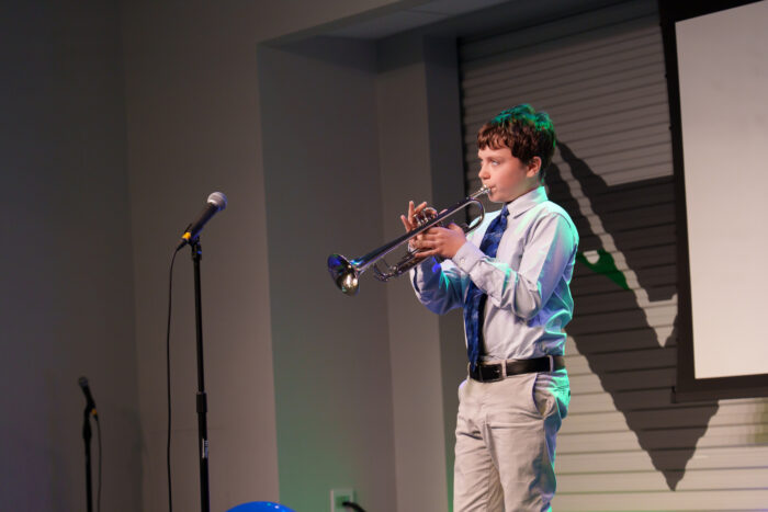 A student plays trumpet on the Lynx Den stage.