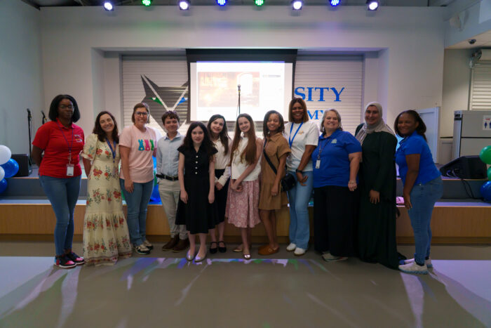 Teachers and students smile for a group photo.