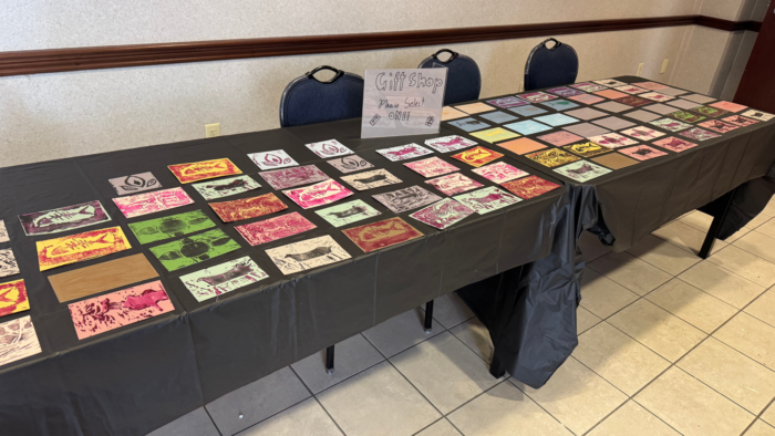 The museum gift shop, a long table displaying various student art