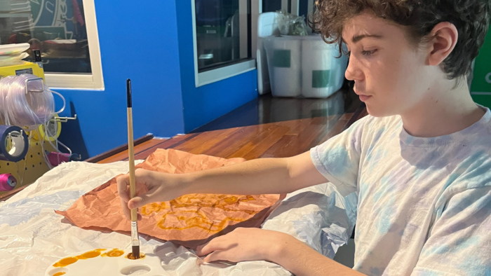 A student concentrates on his painting