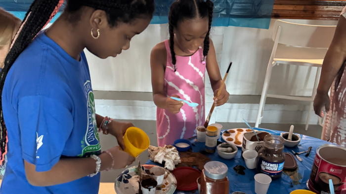 Two students work with paint palettes