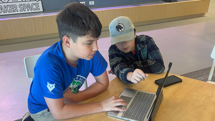 Two students research on a computer
