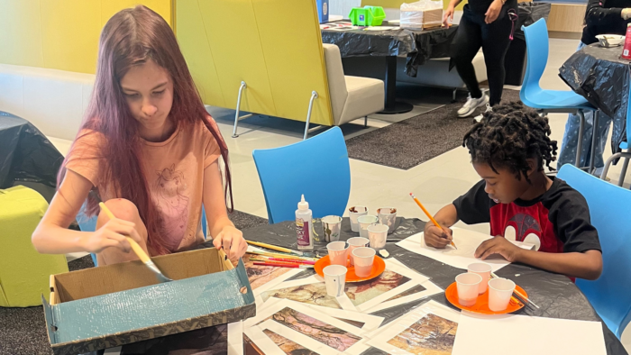 Two students work on their cave paintings and dioramas