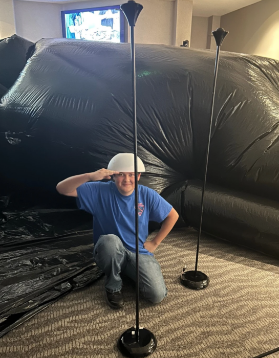 A student salutes the camera in front of the inflatable cave.
