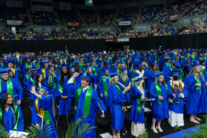 The arena full of graduates cheer as the ceremony is completed.