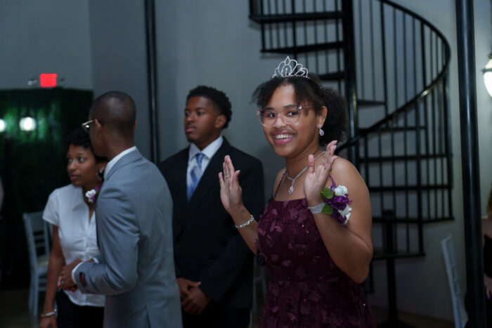A student in a tiara smiles for the camera.