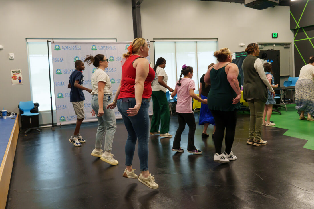 Teachers and students jump and dance.