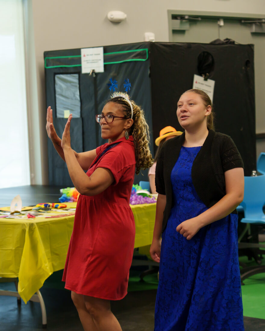 A teacher and a student dance together.