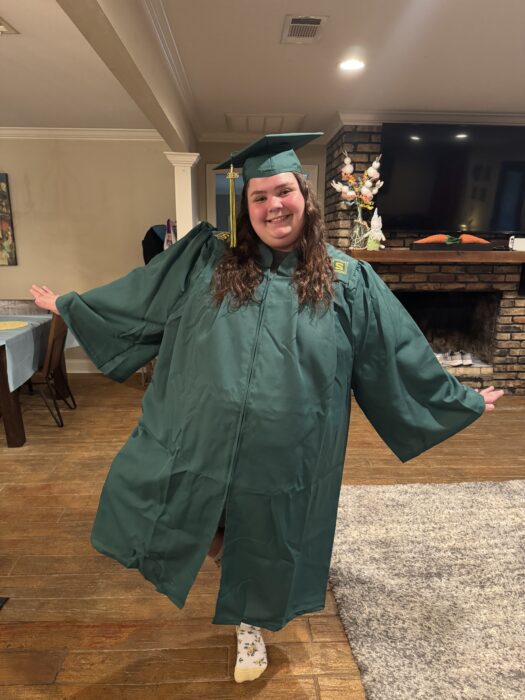 Barnett smiles and poses in a college graduation gown.