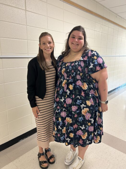 Barnett and her mentor teacher smile for a picture in a school hallway.