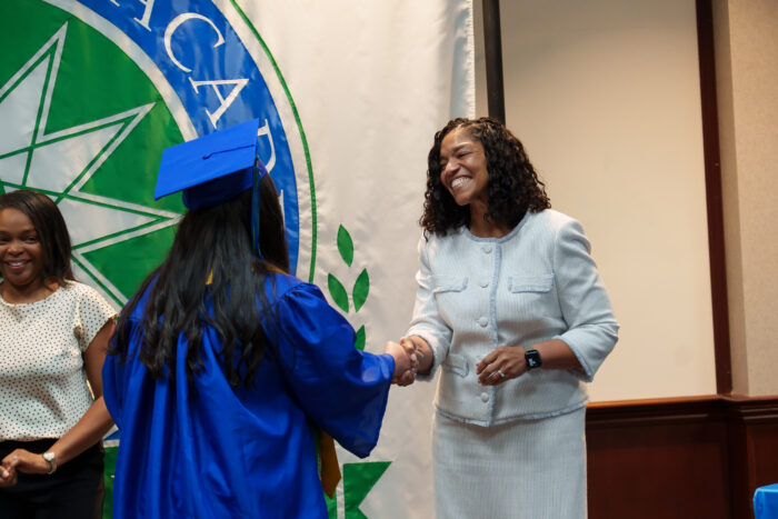 A graduate shakes hands with Superintendent Timoll.