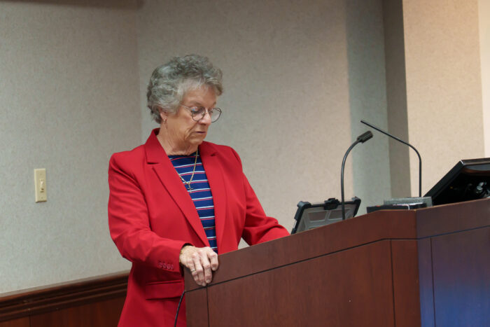 Board President Holliday gives a speech at a podium.