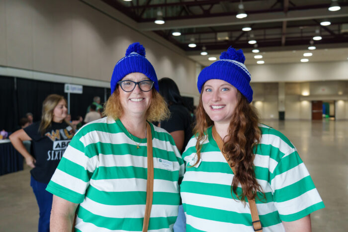 Two teachers in 'Where's Waldo?' costumes smile for the camera.