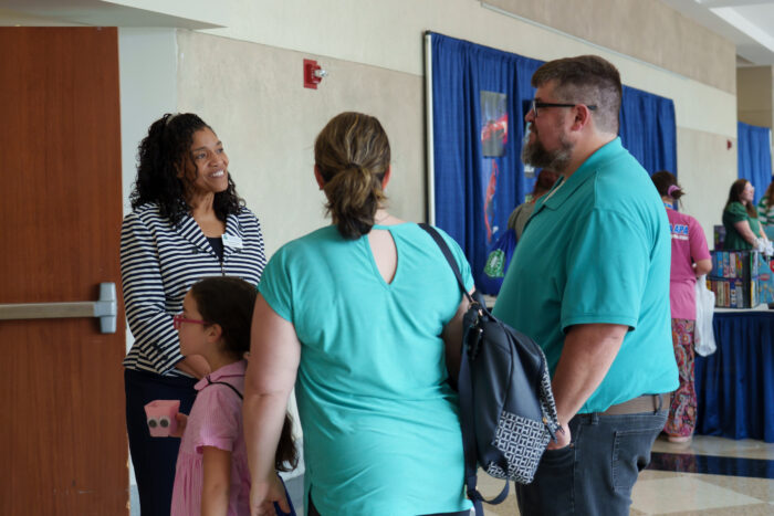 Superintendent Timoll talks with a family at open house.