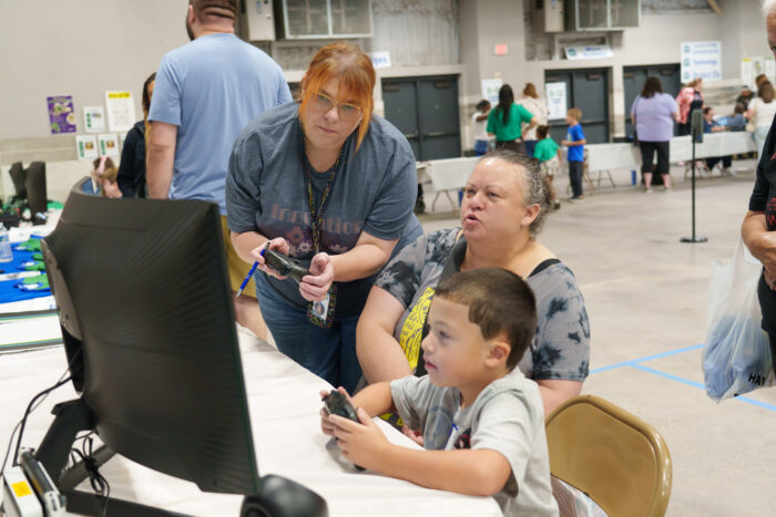 A young student and two women play at the esports station.
