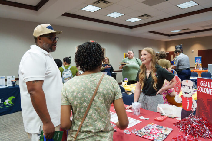 A smiling recruiter talks to a family.