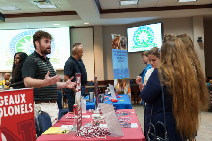 A recruiter talks to a group of students.